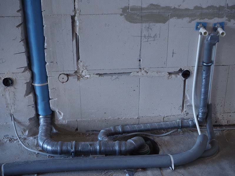 a plumber inspecting the plumbing pipes